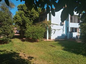 a house with a yard with grass and trees at Recanto verde 3 in Alegrete