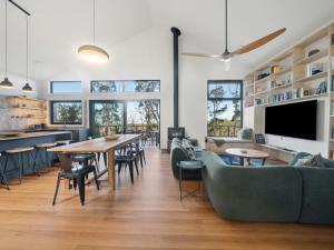 a living room with tables and chairs and a tv at Birdsong Blackheath in Blackheath