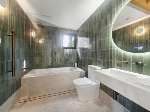 a bathroom with a tub and a toilet and a sink at Birdsong Blackheath in Blackheath +12 photos