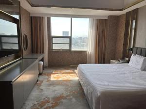 una camera d'albergo con un letto e una grande finestra di Beijing Jingyi Hotel a Pechino Altre 37 foto
