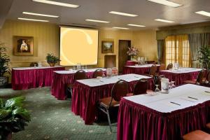 a conference room with red tables and chairs and a screen at Folk Inn Ontario Airport in Ontario