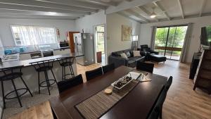 Una cocina y una sala de estar con mesa y sillas. en Drift at Rainbow 4 Bedroom, en Rainbow Beach