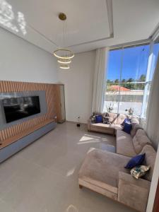 a large living room with a couch and a tv at Casa de Temporada Camaçari in Barra de Jacuípe