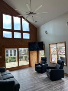 a living room with two chairs and a ceiling fan at Canal Front Boater's Paradise in Kill Devil Hills