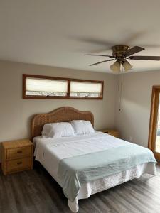a bedroom with a bed and a ceiling fan at Canal Front Boater's Paradise in Kill Devil Hills +26 photos