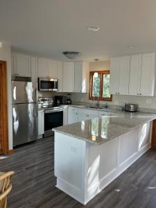 a kitchen with white cabinets and a granite counter top at Canal Front Boater's Paradise in Kill Devil Hills