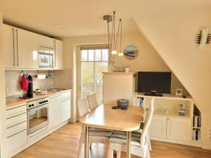 a kitchen with a wooden table and a dining room at Holiday apartment in Wyk with swimming pool in Wyk auf Föhr