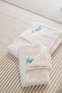 a pair of white towels on a bed at Studios Kiara in Chania Town