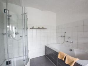 a white bathroom with a tub and a shower at Holiday home Mühle Catharina in Oldenswort +33 photos