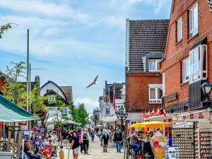 a group of people walking around a street market at Holiday apartment in Wyk with swimming pool in Wyk auf Föhr
