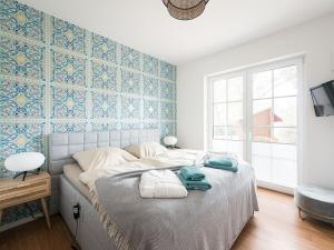 バート・ツヴィッシェンアーンにあるHoliday apartment by the lakeのベッドルーム1室(青いタイル張りの壁の大型ベッド1台付)