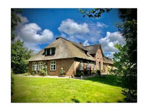 a large brick house with a thatched roof at 1-bedroom apartment in Tating