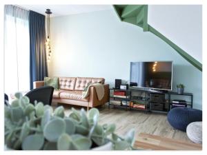 a living room with a couch and a flat screen tv at Waterfront Holiday Home with Terrace Views in Stavoren