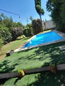 a swimming pool in a yard with potted plants at Complejo Lua in Villa Cura Brochero