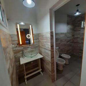 a bathroom with a sink and a toilet and a mirror at Complejo Lua in Villa Cura Brochero +8 photos