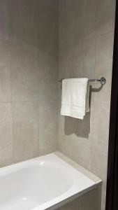 a bathroom with a tub and a white towel at Trendy Stay Apartments in Muscat