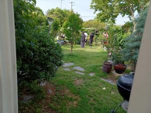 a garden with trees and people walking in the yard at Pohang Mimi House Pension in Pohang
