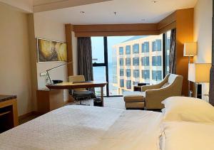 Postel nebo postele na pokoji v ubytování Sheraton Yantai Golden Beach Resort