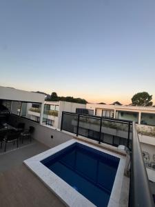 ein Balkon mit einem Swimmingpool auf einem Gebäude in der Unterkunft Casa Residencial Recreio dos Bandeirantes in Rio de Janeiro