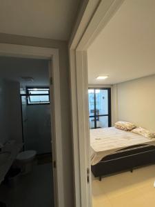ein kleines Schlafzimmer mit einem Bett und einem Badezimmer in der Unterkunft Casa Residencial Recreio dos Bandeirantes in Rio de Janeiro + 1 Foto