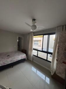 ein Schlafzimmer mit einem Bett und einem großen Fenster in der Unterkunft Casa Residencial Recreio dos Bandeirantes in Rio de Janeiro