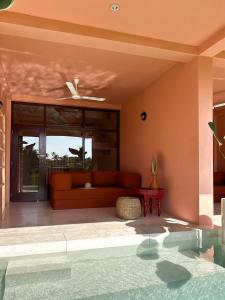 a living room with a couch and a pool at Casa Tikiri - PADDY LODGE Adults-Only in Ahangama