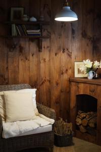 a living room with a chair and a fireplace at Maison De Oliu in Ấp Thiện Lập
