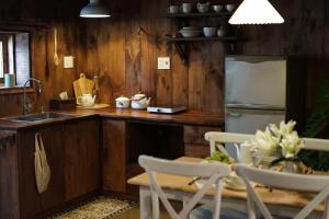 a kitchen with a refrigerator and a table with chairs at Maison De Oliu in Ấp Thiện Lập