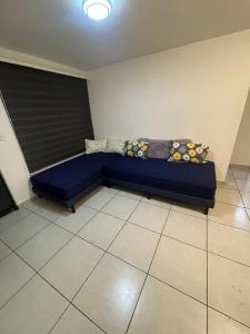 a blue couch with pillows on it in a room at Depa a pasos del Autódromo in Mexico City