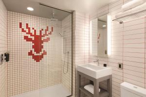 un bagno con lavandino e doccia con specchio di Radisson Red Minneapolis Downtown a Minneapolis