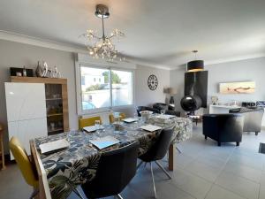 ein Esszimmer und ein Wohnzimmer mit Tisch und Stühlen in der Unterkunft Spacieuse Maison avec Piscine Privée - Cœur de Saint Jean de Monts - FR-1-323-381 in Saint-Jean-de-Monts + 27 Fotos