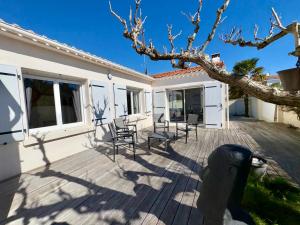 eine Terrasse mit Stühlen und einem Baum in der Unterkunft Spacieuse Maison avec Piscine Privée - Cœur de Saint Jean de Monts - FR-1-323-381 in Saint-Jean-de-Monts