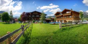 a large house in a field with a fence at Ferienwohnungen Tannheim - bei Martina Fügenschuh - Sommerbergbahn inklusive - ruhige Lage direkt an Lift & Loipe in Tannheim
