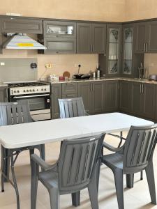 a kitchen with a white table and chairs at The Moon Resort in Al Ain