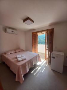 a bedroom with a bed with two towels on it at Suíte 3 Vila dos Pescadores Condomínio Portogalo in Angra dos Reis
