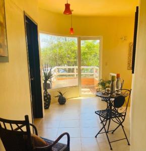 a living room with a table and chairs and a window at Quinta Duné Boutique - Un Paraíso Frente Al Mar in Chachalacas