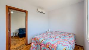 a bedroom with a bed and a mirror and a blue chair at Europa Place in Porto Alegre