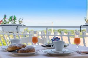 una mesa con platos de comida y bebida en el balcón en Hotel Ristorante Colleverde, en Santa Maria di Castellabate