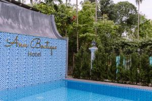 Una piscina con una pared de azulejos azules al lado de una valla. en Ann Boutique Hotel, en Thôn Dương Xuân Hạ
