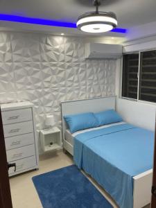 a bedroom with two twin beds and a blue light at Apartmento Xbox WFI TV65 PC Love Relax Work in La Cana