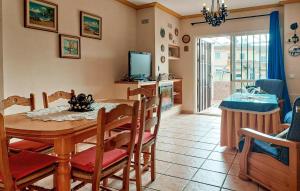 a dining room with a table and chairs and a television at 5 Bedroom Cozy Home In El Portil in El Portil