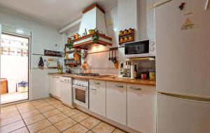 a kitchen with white cabinets and a refrigerator at 5 Bedroom Cozy Home In El Portil in El Portil +19 photos