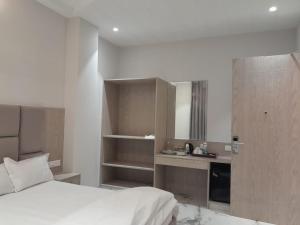 a hotel room with a bed and a kitchen at The Royal Inn in Bāba Bakāla +7 photos