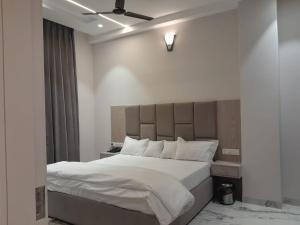 a bedroom with a large bed with white sheets and pillows at The Royal Inn in Bāba Bakāla
