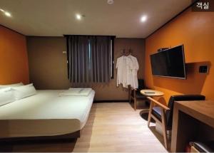 une chambre d'hôtel avec un lit et une télévision dans l'établissement Nampo Foxy Hotel, à Busan