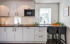 奥尔延Amazing Home In Årjäng With Lake View的厨房配有白色橱柜、水槽和柜台。 更多11张照片