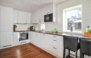 奥尔延Amazing Home In Årjäng With Lake View的白色的厨房配有白色橱柜和窗户