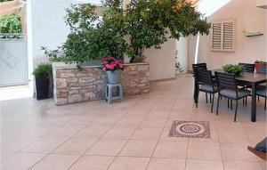 a patio with a table and chairs and plants at Cozy Apartment In Supetar in Supetar +12 photos