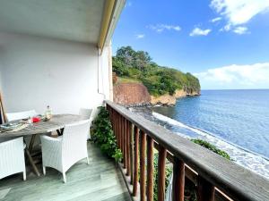 a balcony with a table and chairs and the ocean at Fare Mahina ocean view in Mahina
