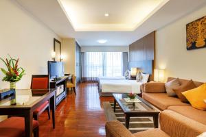 a hotel room with a bed and a couch at Kantary House Hotel, Bangkok in Bangkok